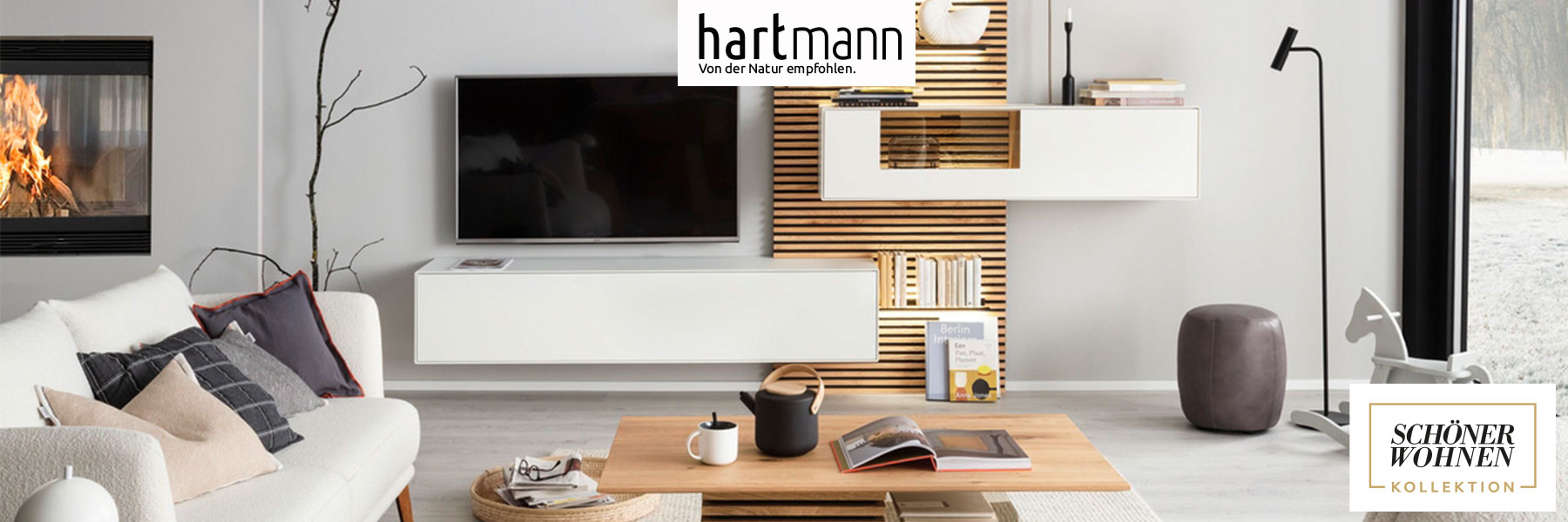 Hartmann Möbel - Möbelserie YONNA Schöner Wohnen Kollektion - Birke Lack weiß Hartmann YONNA - Wohn und Garderobenmöbel aus Birke weiß lackiert kombiniert mit Kerneiche Natur und Holzlamellen. Ambientebild zeigt ein weißes Hängelowboard und weiße Hängevitrine eingefasst in ein Holz-Lamellenpaneel mit beleuchteten Glasböden.
