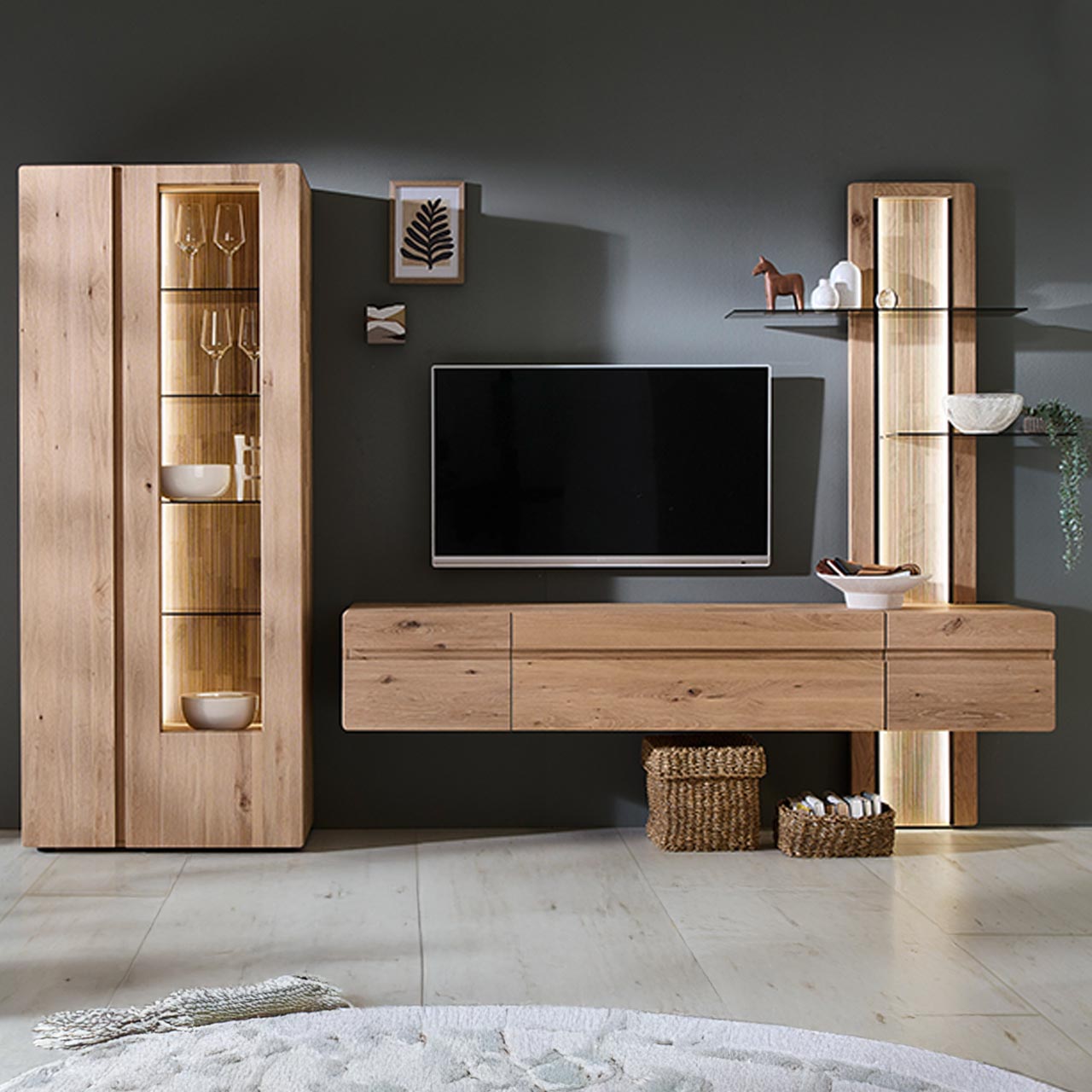 Hartmann VIDA - Wohnkombination 8630 Nr. V26 - zweiteilig - Kerneiche Natur Moderne dreiteilige Wohnwand aus massiver Kerneiche Natur bestehend aus einer Standvitrine mit zwei Türen, einem Hängelowboard und einem integriertem Aufsatzpaneel mit beleuchteten Glasböden und geschroppter Rückwand.
