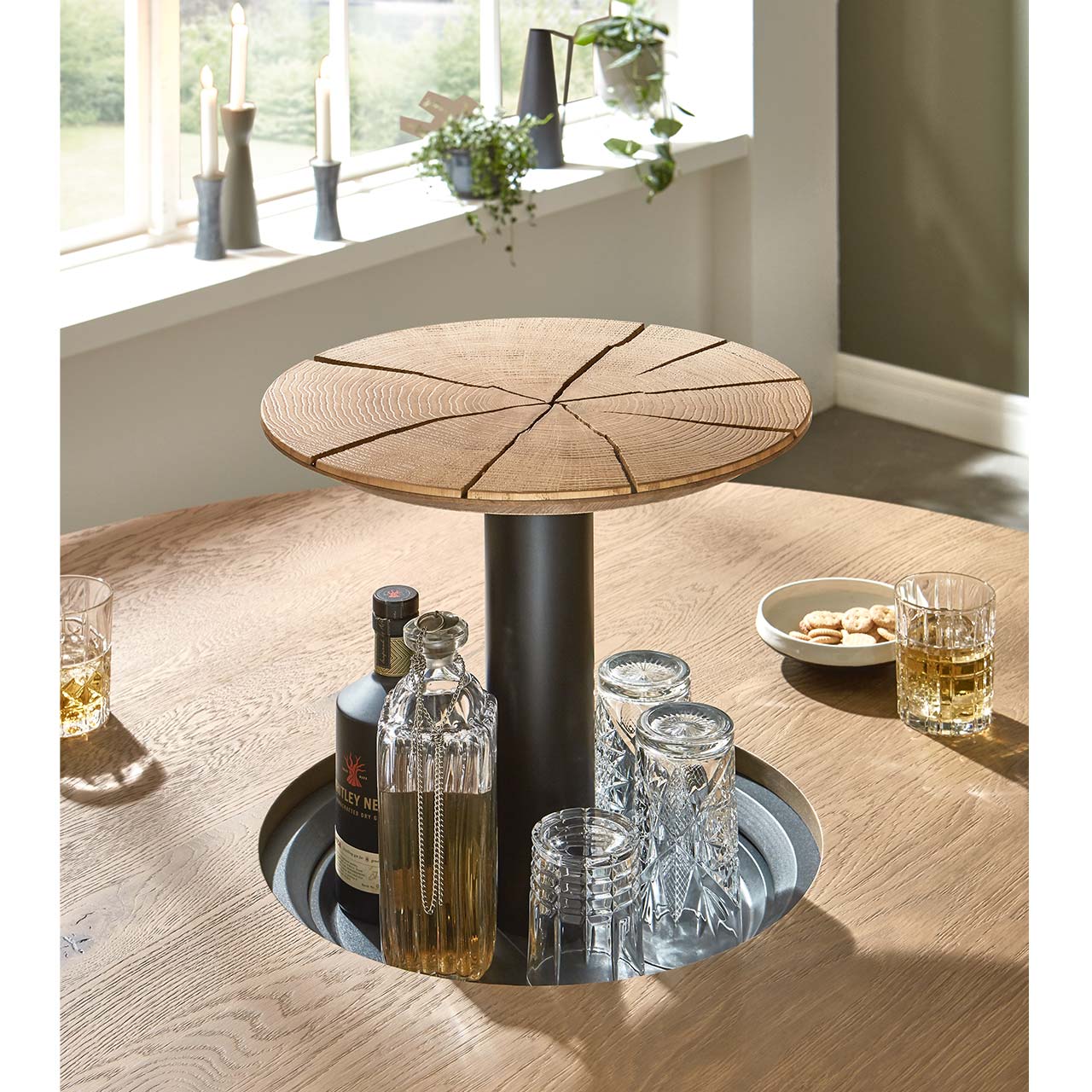 Detailaufnahme eines ausfahrbaren Flaschenfaches, integriert in einem Holztisch. 