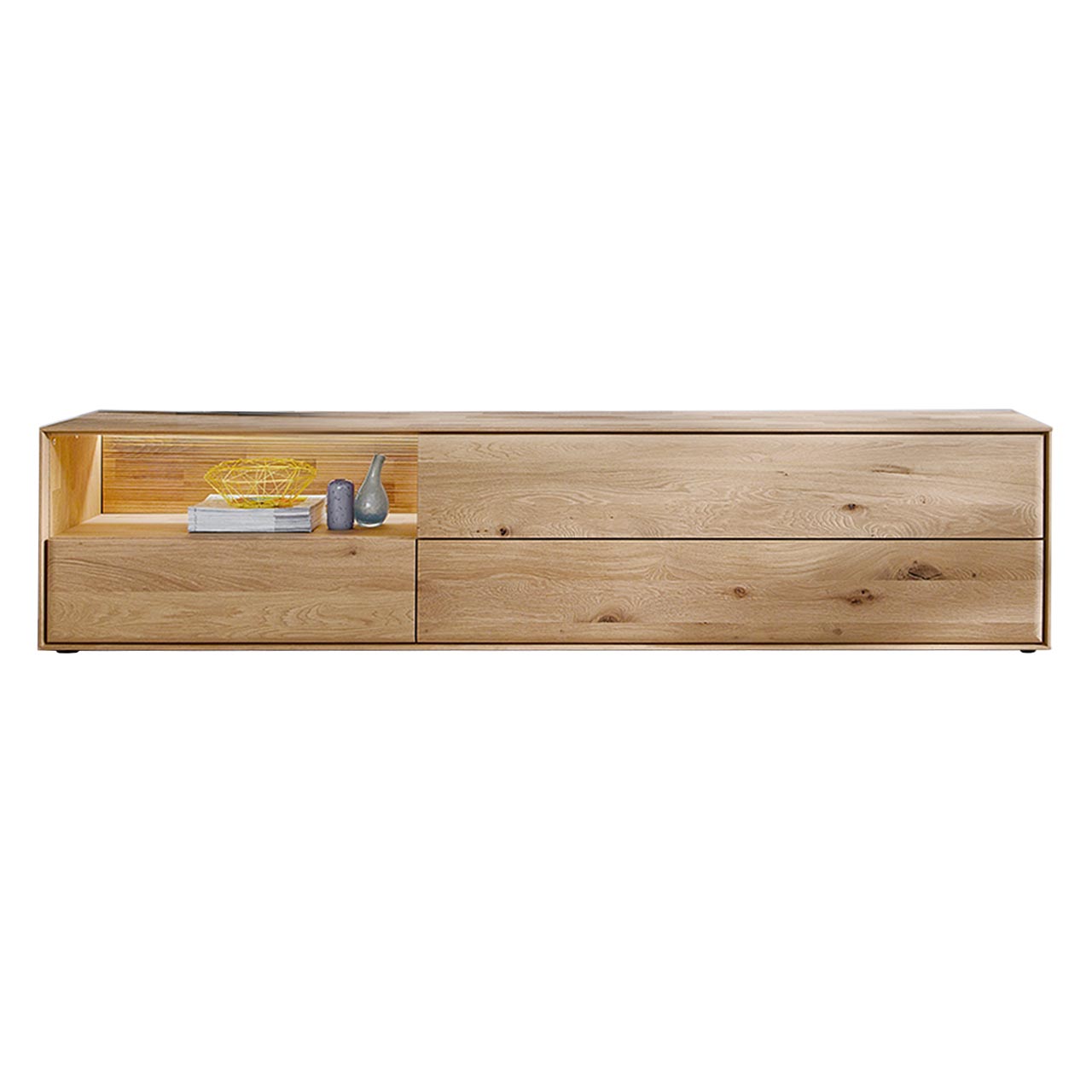 Hartmann VALA - Lowboard 8640-3242 - Kerneiche Natur Modernes Lowboard aus massiver Kerneiche Natur mit zwei Schubkästen unten, einer beleuchteten Nische mit geschroppter Rückwand links und einer Klappe rechts - in Frontansicht.