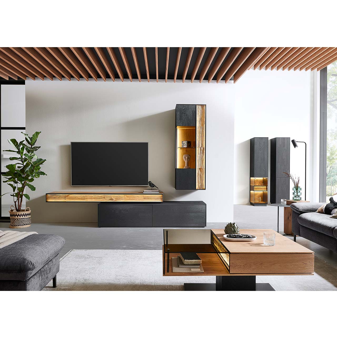HM_KILVA_9610-8054re-_Ha-ngeelement_milieu_1280x1280 Moderne Wohnwand mit Materialmix aus Lack anthrazit mit Spaltholz-Akzenten und Parsolglas-Vitrinenausschnitten