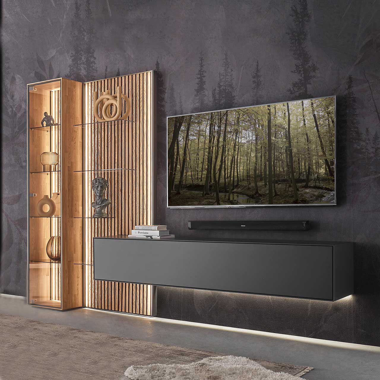 Hartmann SELINO - Wohnwand 8560 Nr. V22 Modernes Wohnzimmer mit Fernseher und moderner dreiteiliger Wohnwand aus massivem Holz: Ein schlichtes Hängelowboard anthrazit lackiert, eine Standvitrine und ein Wandpaneel mit hellen Holzlamellen und Glas – vor dunkelgrauer Wand.
