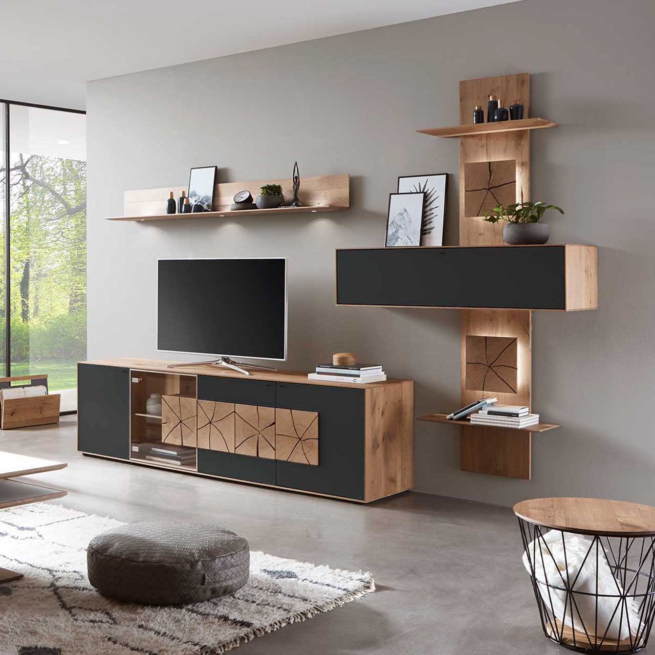 Moderne dreiteilige Massivholz Wohnwand aus Kerneiche Umato mit Mattglas anthrazit Fronten: Lowboard mit Glasausschnitt und Hirnholz, Wandregal aus Holz, schlichter Hängeschrank eingefasst in ein Holzwandpaneel mit Ablageböden.
