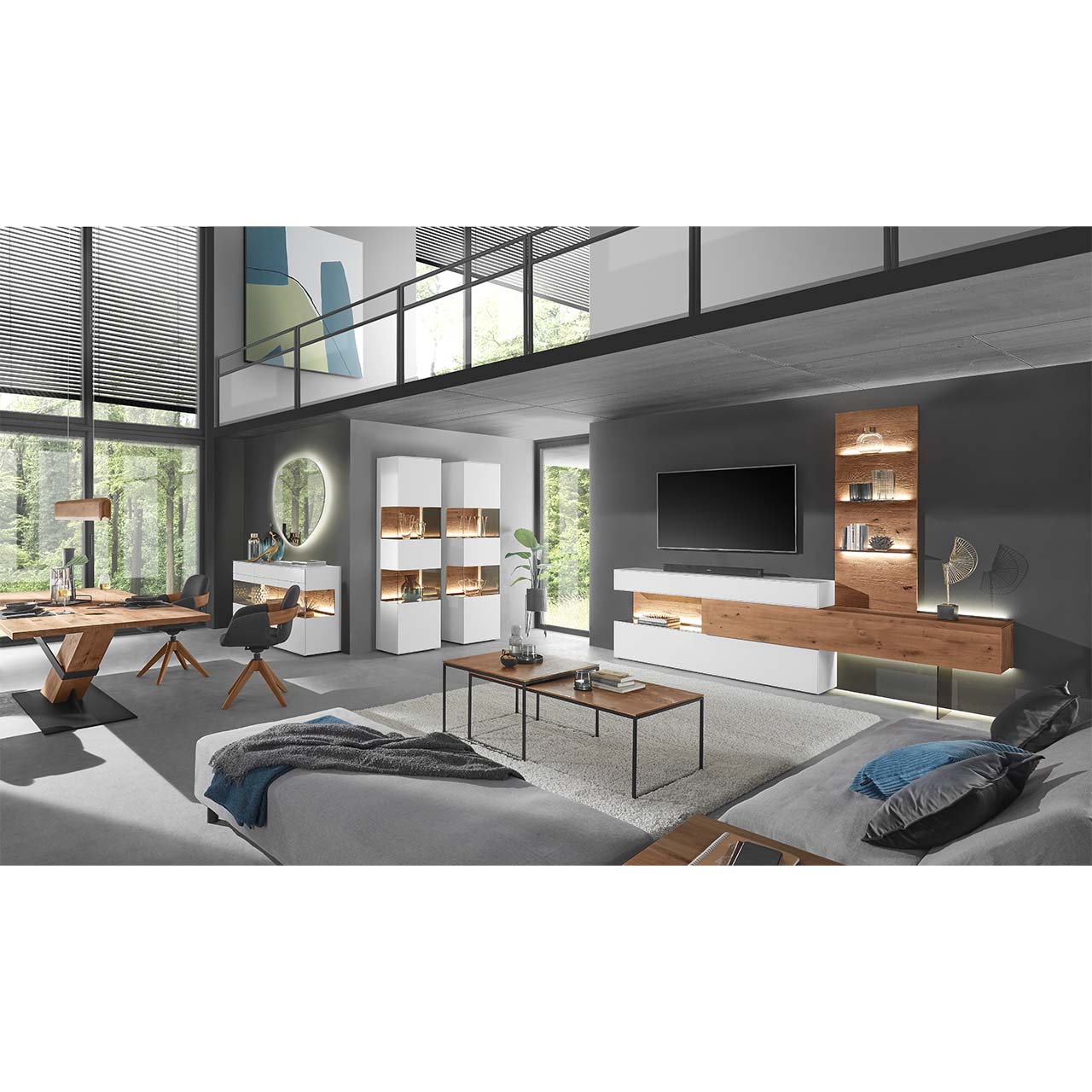 Moderne Wohnung mit Wohnwand aus massiver Birke in Lack weiß und dunkler Kerneiche: Lowboard, weißer Ober - und Unterschrank, beleuchtetes Wandpaneel, davor zwei rechteckige Couchtische. Links an der Wand zwei weiße Standvitrinen neben Holzesstisch.