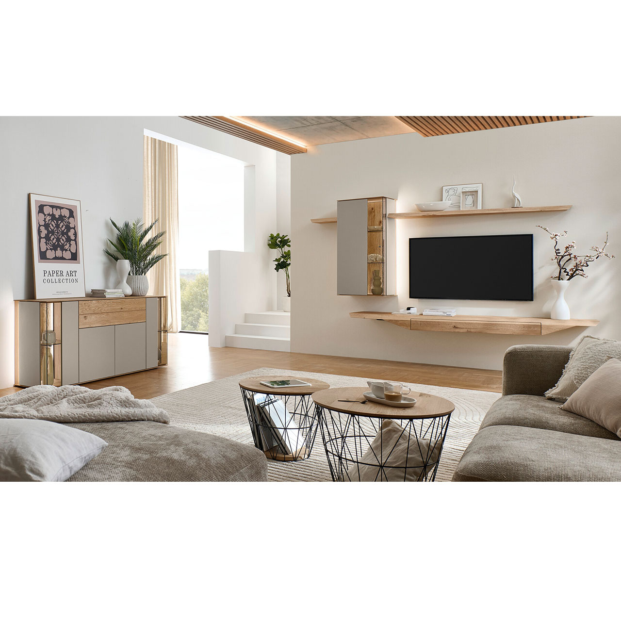 Wohnzimmer mit moderner Massivholzwohnwand bestehend aus Hängelowboard mit Schubkasten, Hängevitrine sowie zwei Wandboarden mit Holzboden - im asymmetrischen Design. Links passendes Highboard mit Glastüren, davor zwei runde Couchtische.