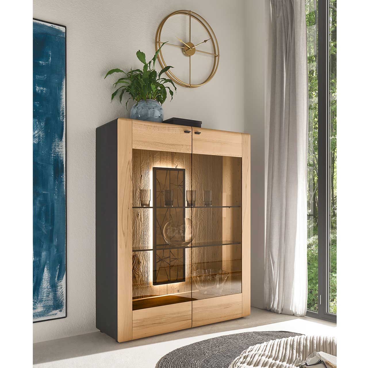 Im Wohnzimmer stehendes Highboard aus massiver Kernbuche mit großer Glasfront aus bronzefarbenem Parsolglas. Dahinter sichtbare Rückwand mit dekorativen Hirnholzscheiben.