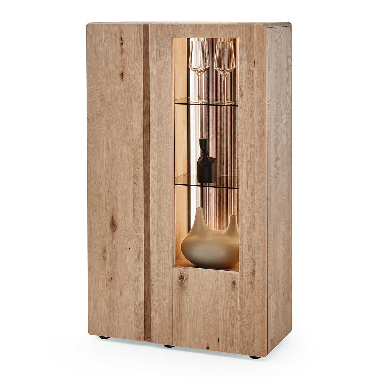Edles Highboard aus massiver Kerneiche Natur mit einer Holztür links und einer beleuchteten Glas-/Holztür rechts, dahinter sichtbar die edel geschroppte Rückwand und die Glasböden - in Seitenansicht. 