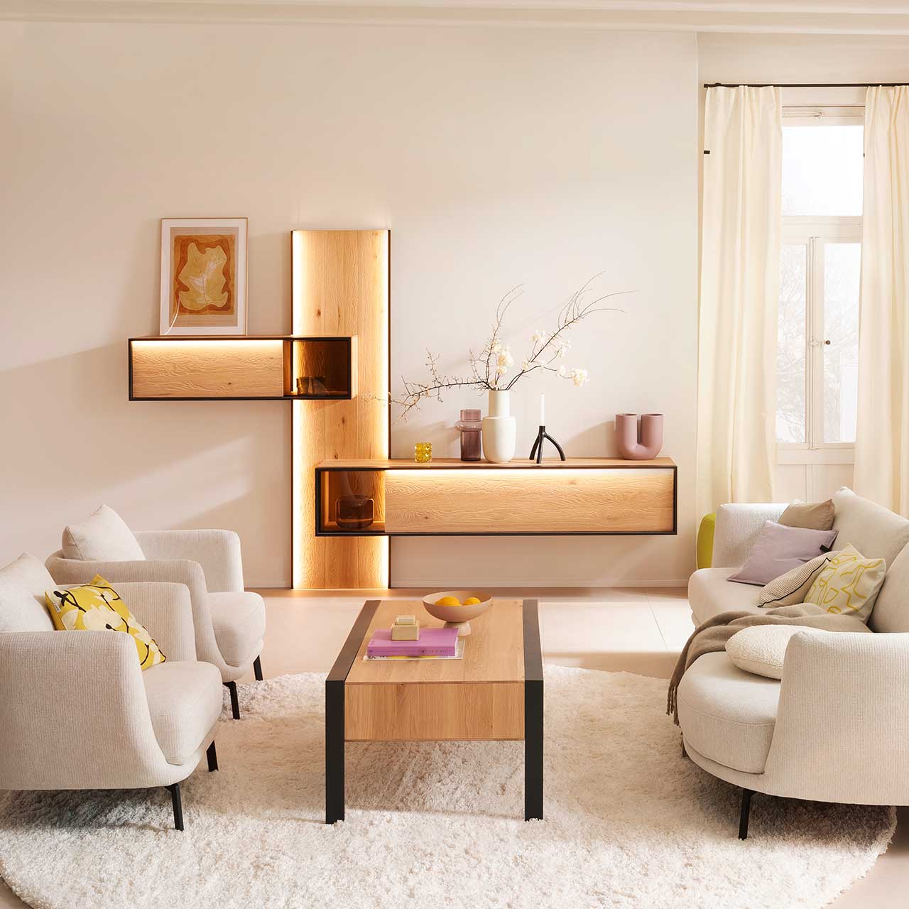 Wohnzimmer mit Wohnwand aus sandgestrahlter Kerneiche Natur mit anthrazitfarbenem Metallrahmen, Hängeregal mit Glasausschnitt, Hängelowboard mit Glasdetail, kombiniert am langen beleuchtetem Wandpaneel. Davor passender Holz-Couchtisch.