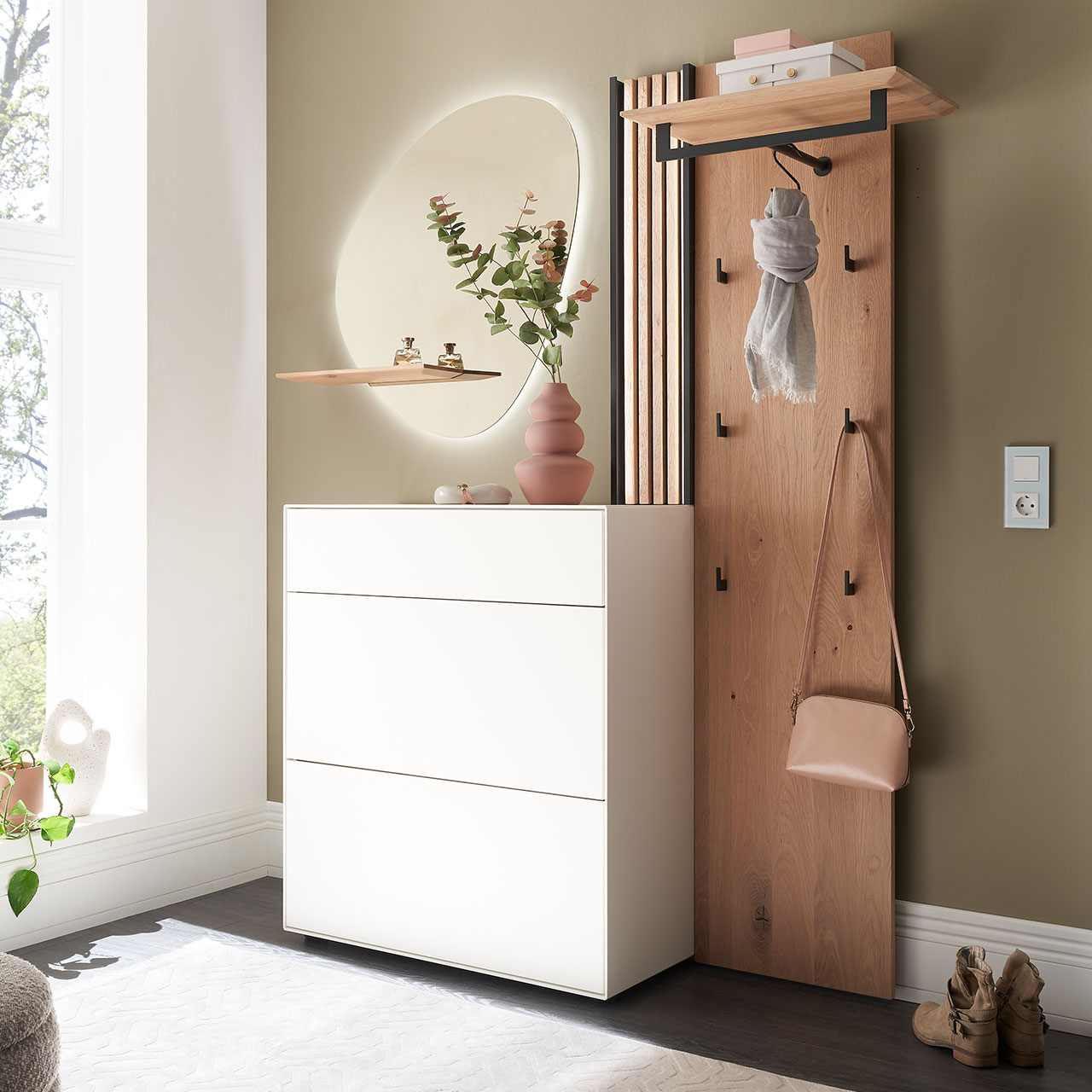 Hartmann SALVO 8550G - Garderobe Nr. V106S - Kernbirke weiß Lack, Kerneiche Natur, Spaltholz Moderne dreiteilige Garderobe aus Kernbirke und Kerneiche Natur: Wandpaneel aus Holz mit Kleiderstange, Haken und Lamellen-Akzent, ein Stauraumschrank mit Schubkasten und Klappen in Lack weiß und ein ovaler Spiegel mit Ablage.