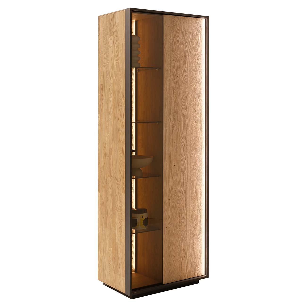 Seitenansicht einer Standvitrine mit Sockel im modernen Design aus sandgestrahlter Kerneiche Natur, eingefasst in einen Metallrahmen in Anthrazit, mit geteilter Tür: links beleuchteter Glasausschnitt mit vier Glaseinlegeböden, rechts Holz 