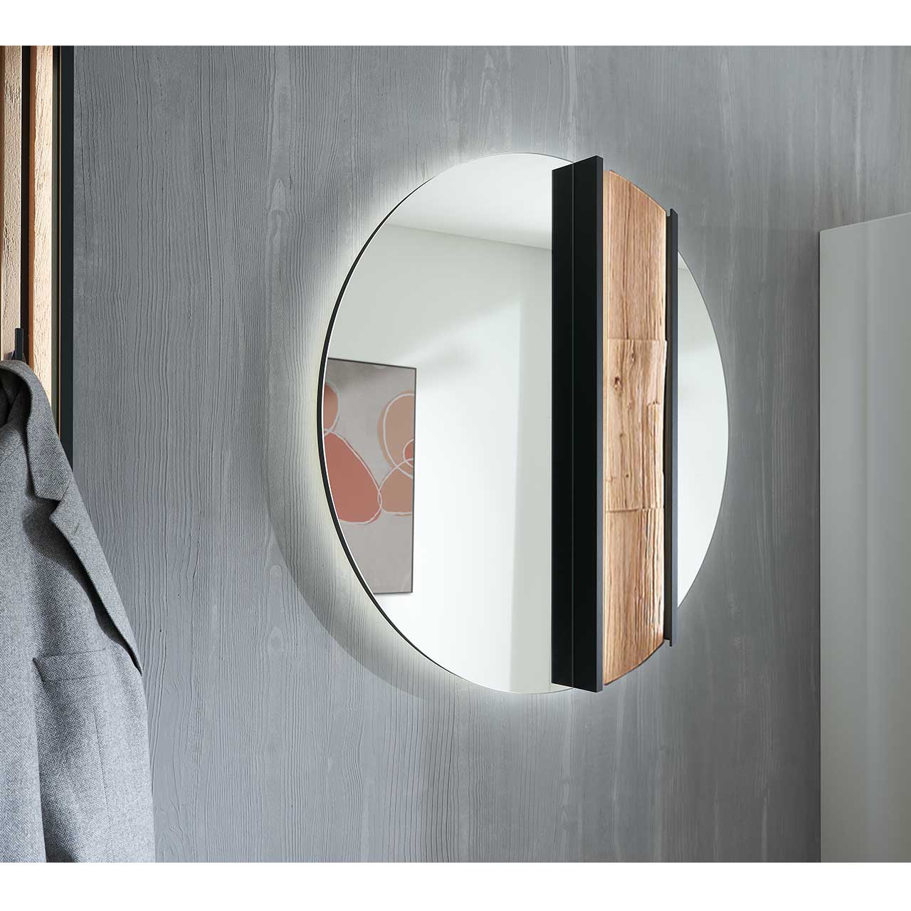 Seitenansicht eines runden Wandspiegels, rechts mit Spaltholz-Akzent eingefasst in einen anthrazitfarbenen Metallrahmen.