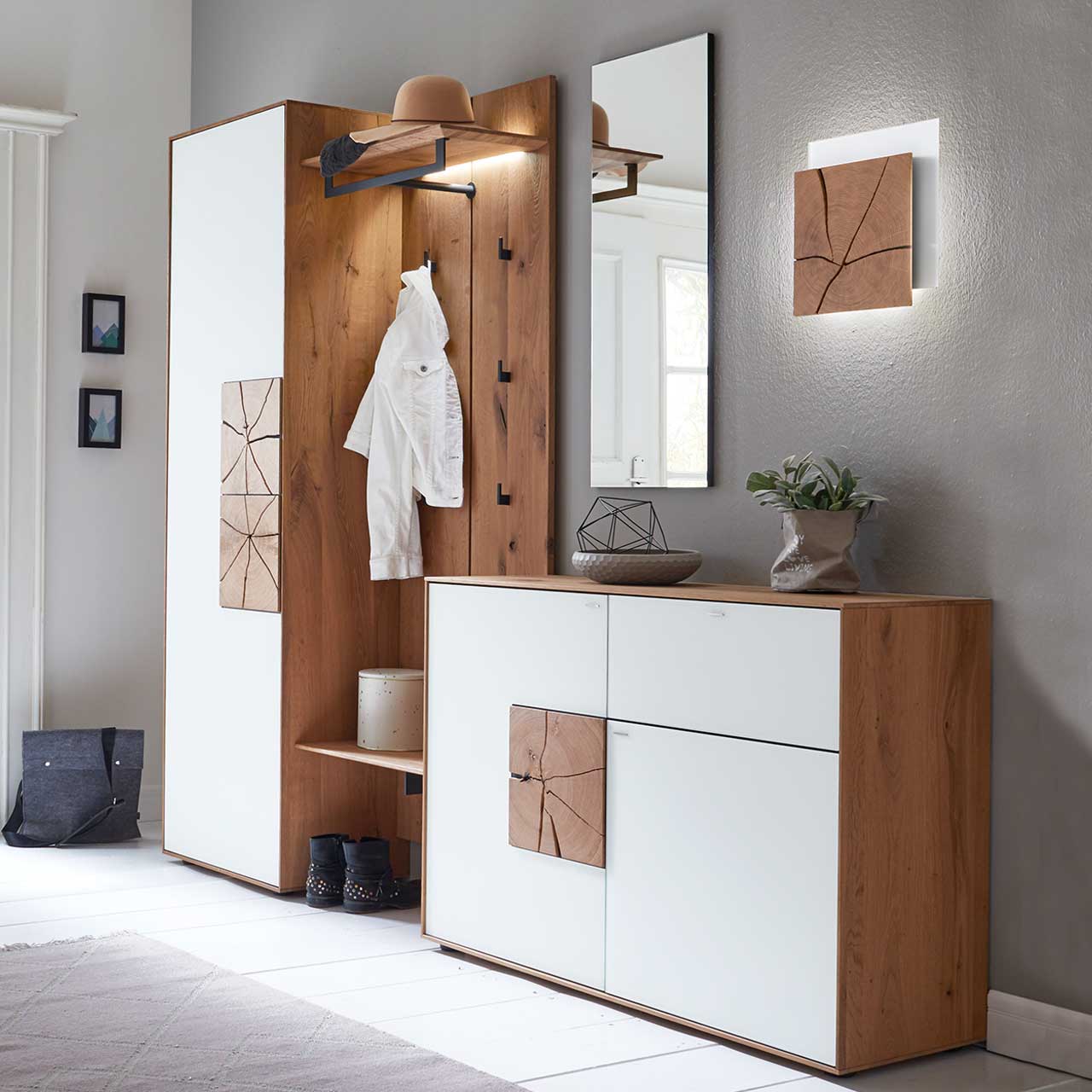 Hartmann CAYA Garderoben - Kombination 7140 Nr. V100 - fünfteilig Moderne, fünfteilige Garderobe aus massiver Kerneiche mit beleuchtetem Spiegel und Wandleuchte, Kommode und hohem Stauraumschrank mit weißen Mattglasfronten und Hirnholzkacheln und einem Wandpaneel mit Stange, Ablagen und Haken – vor dunkler Wand