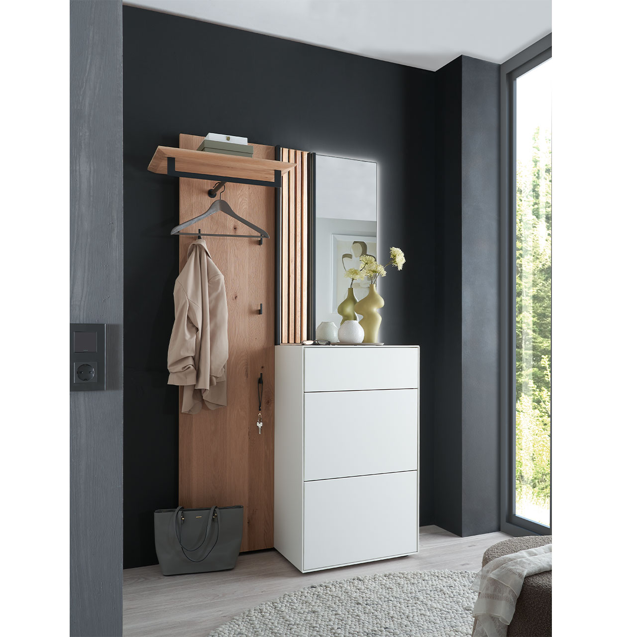 Milieubild Hartmann SALVO 8550G -  Garderobe Nr. V106L - Kernbirke weiß Lack, Kerneiche Natur, Lamellen Flur mit modernen Garderobenmöbeln aus Kernbirke und Kerneiche Natur: Wandpaneel aus Holz mit Kleiderstange, Haken und Lamellen-Akzent, ein Stauraumschrank mit Schubkasten und Klappen in Lack weiß, ein rechteckiger Spiegel.