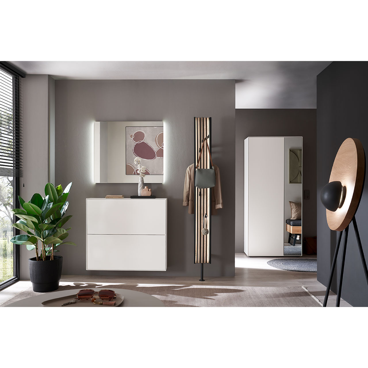 Milieubild Hartmann SALVO 8550G -  Garderobe Nr. V122L - Kernbirke weiß Lack, Lamellen Flur mit modernen Garderobenmöbeln aus massiver Kernbirke weiß lackiert: Ein Schuhkipper in Lack weiß, ein Garderobenpaneel mit Kleiderstange, Mantelhaken und Lamellen-Akzent und ein rechteckiger Wandspiegel.