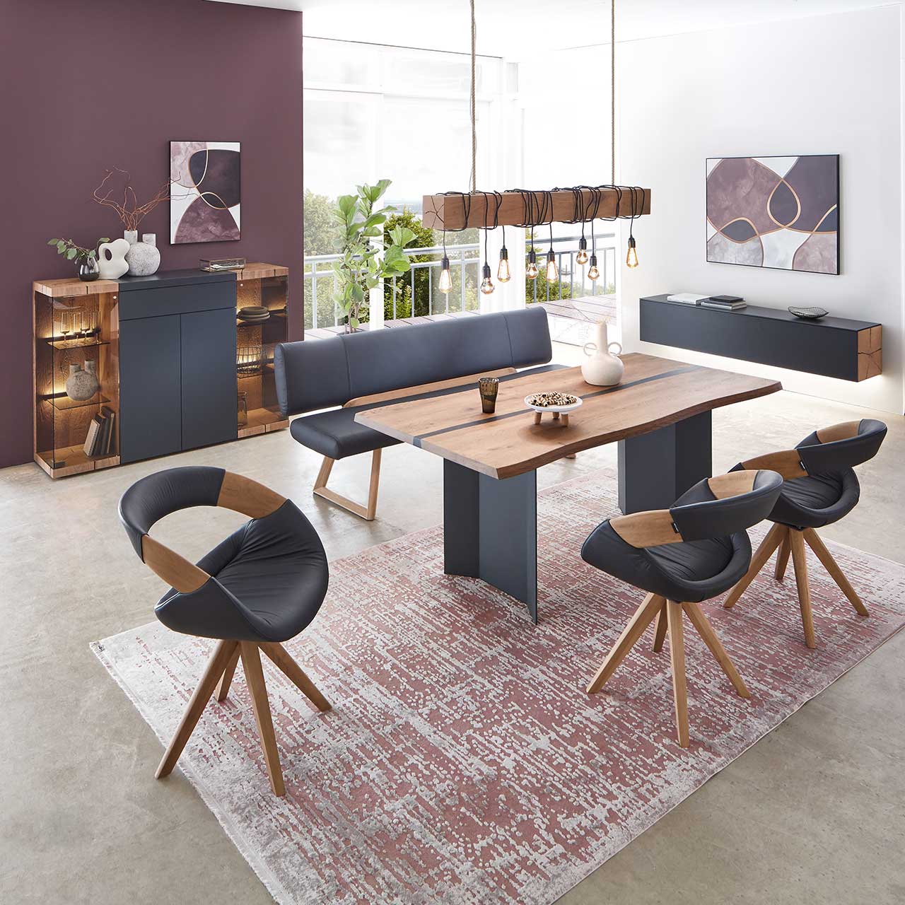 Modernes Esszimmer mit rechteckigem Holztisch, umgeben von vier Stühlen und der passenden Polstersitzbank. Darüber hängend eine Balkenleuchte aus Holz. Hinten an der Wand stehend die passenden Esszimmermöbel.