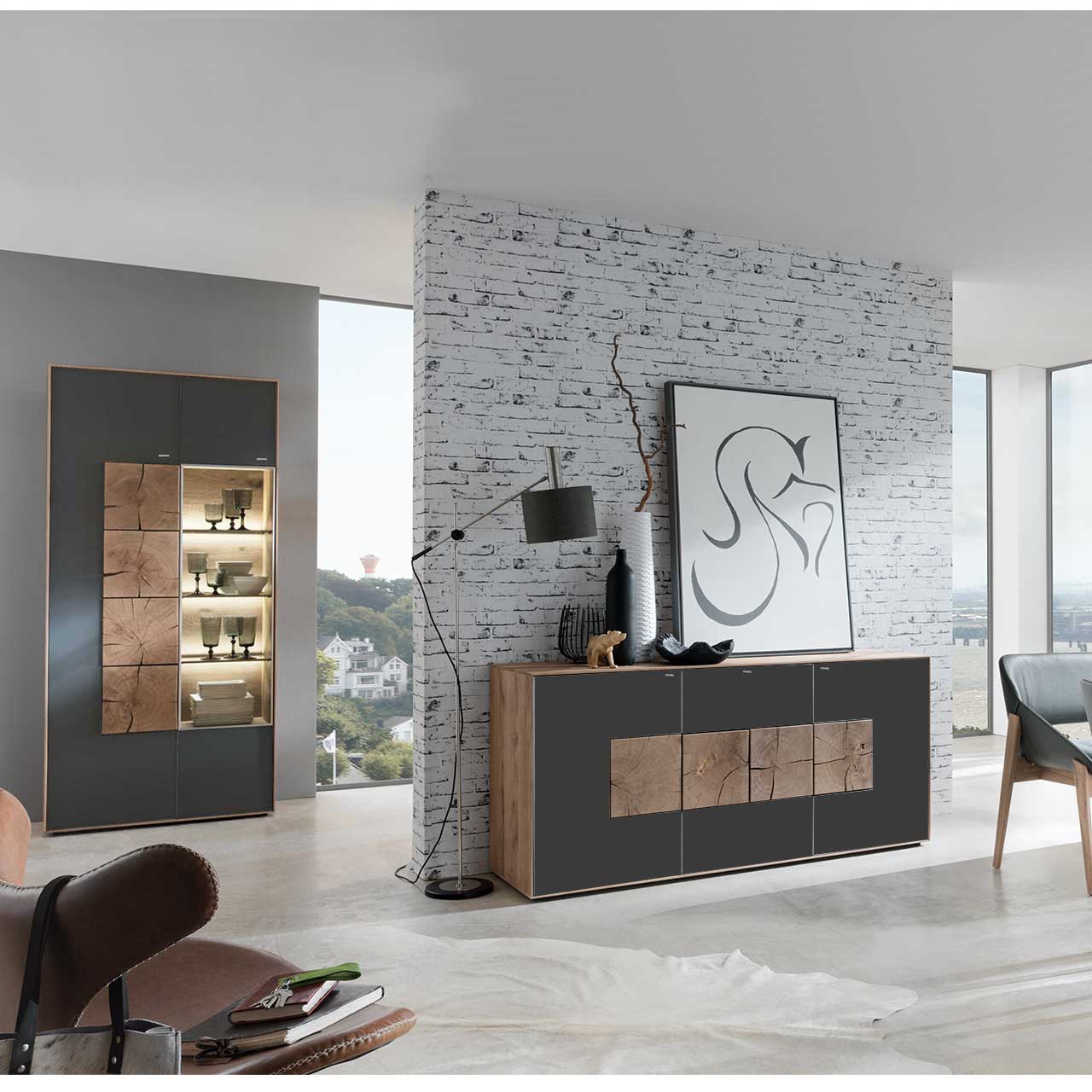Flur mit modernem Sideboard aus massivem Holz mit Mattglas anthrazit Front und vier Hirnholzscheiben. Im Hintergrund an einer Wand stehend eine Strandvitrine in Mattglas anthrazit und beleuchtetem Glasausschnitt mit drei Glasböden