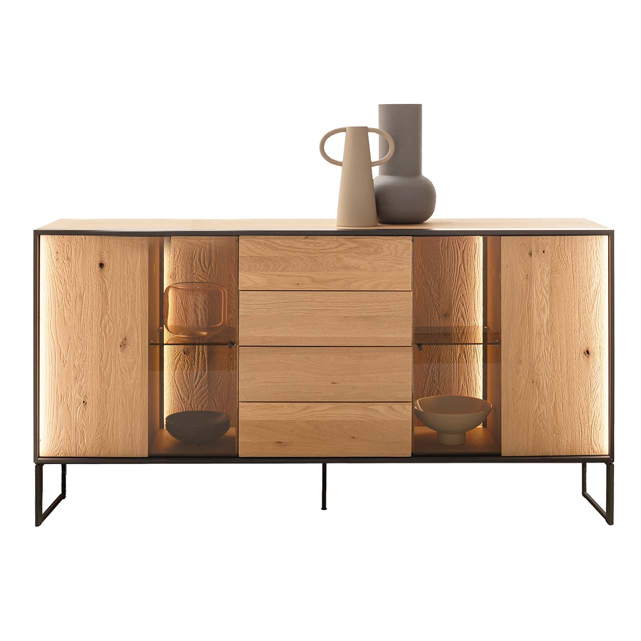 Hartmann YOLA Schöner Wohnen - Sideboard mit hohen Kufen 8590-4194 Modernes Sideboard aus massiver, sandgestrahlter Kerneiche Natur mit beleuchtetem Metallrahmen und zwei filigranen Metallfüßen in Anthrazit. In der Mitte ein Schubkasten und eine Tür, links und rechts Türen mit beleuchteten Glasausschnitten.
