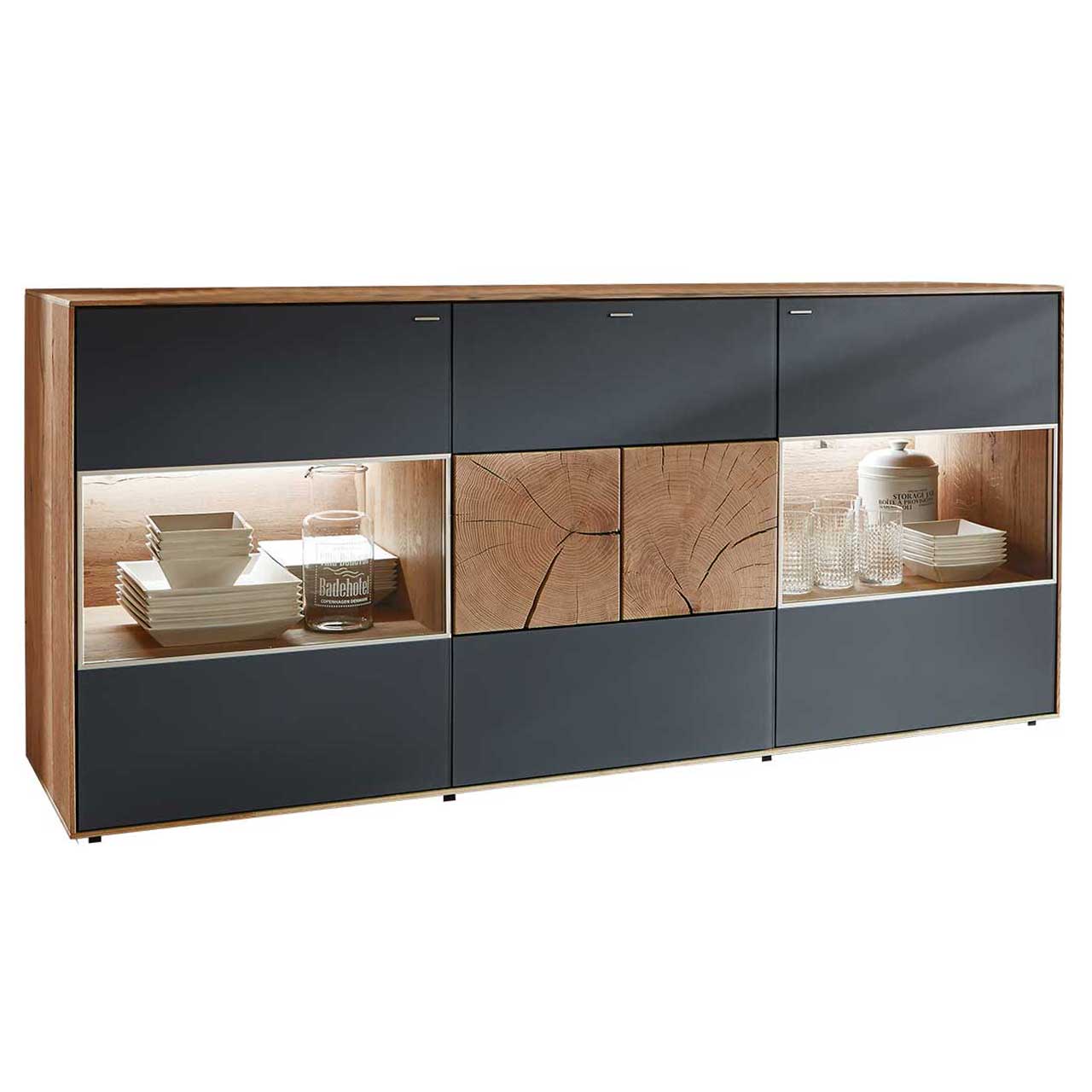 Modernes Sideboard aus massiver Kerneiche Umato mit anthrazitfarbenen Mattglasfronten. Rechts und links mit beleuchtetem Glasausschnitt, mittig mit zwei dekorativen, rechteckigen Hirnholzscheiben.