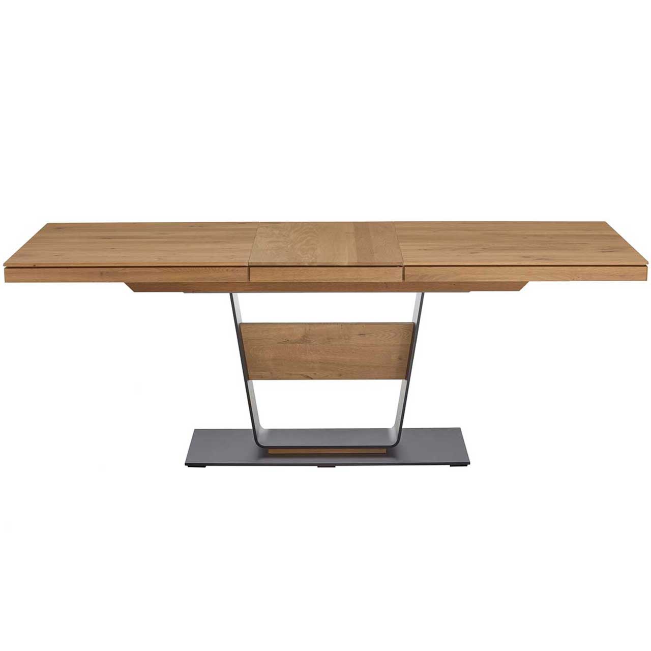 Moderner Esstisch mit rechteckiger, ausgezogener Tischplatte aus massiver Kerneiche Umato. Das Gestell besteht aus einer V-förmigen Stahlsäule mit mittigem Holzelement und steht auf einer dunkelgrauen Metallbodenplatte.